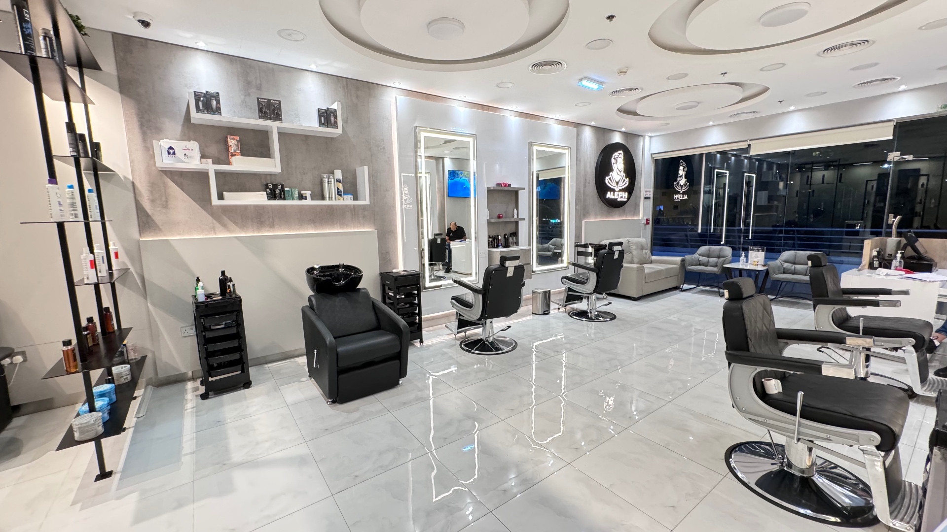 Aleph Gents Salon floor in JLT Dubai with barber chairs, backlit mirrors and product shelves